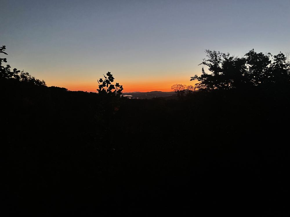 Deep orange dawn sky over a dark Blue Ridge mountain ridgeline in Fannin County, Georgia